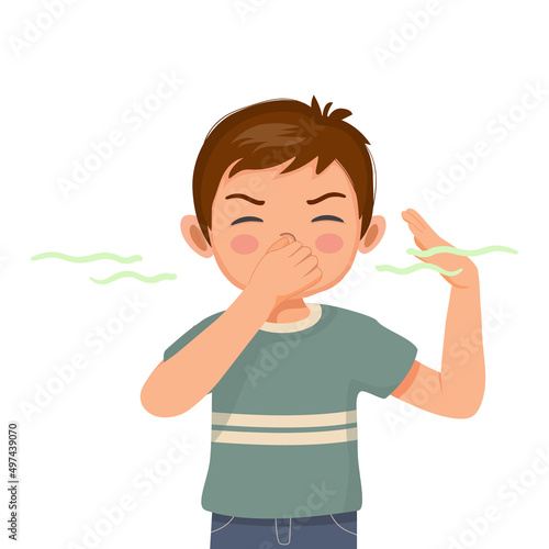 cute little boy pinching and cover his nose smelling something stinky and bad aroma holding breath with fingers on nose