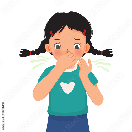 cute little girl pinching and cover her nose smelling something stinky and bad aroma holding breath with fingers on nose