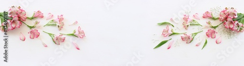 Top view image of pink and purple flowers composition over wooden white background .Flat lay