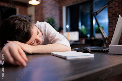 Exhausted executive manager suffering from sleepiness after overtime working hours. Tired office worker with burnout syndrome sleeping at work because of extreme fatigue.