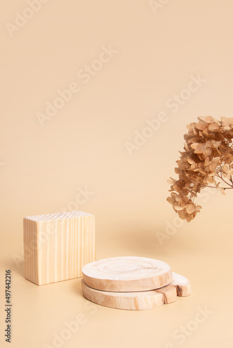 Wooden podium or pedestal for cosmetics, perfumes or jewelry. Neutral beige monochrome with dry flowers mok ap, blank