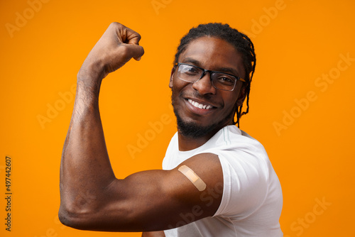 Young black man got vaccinated from coronavirus against yellow background