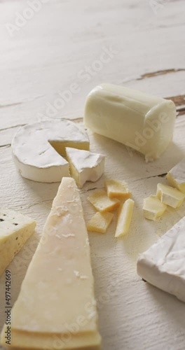 Vertical video of few types of cheese on white rustic background photo