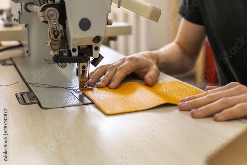 Schilderij op canvas Close up craftsman hands sew stuff blank for wallet use sewing machine