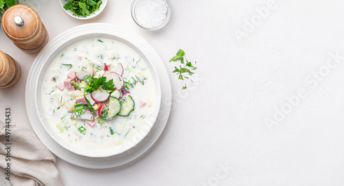 Okroshka, summer, cold soup with vegetables, fresh herbs and kefir. Top view, copy space.