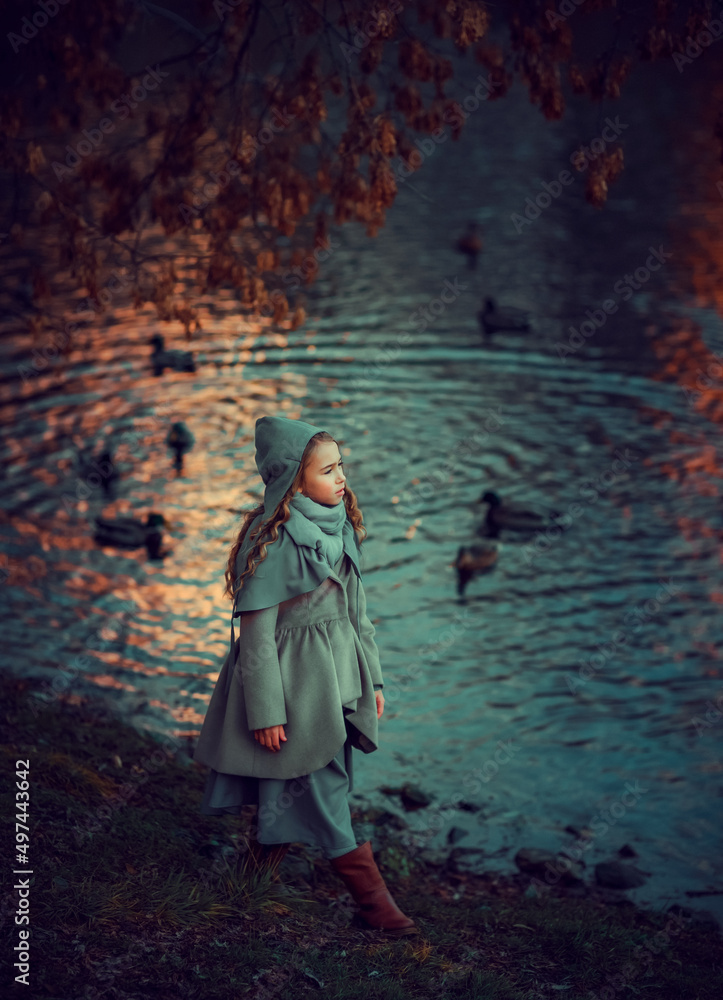 Girl walking in the park near the pond with ducks
