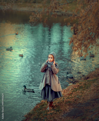 Fototapeta Naklejka Na Ścianę i Meble -  Girl walking in the park near the pond with ducks