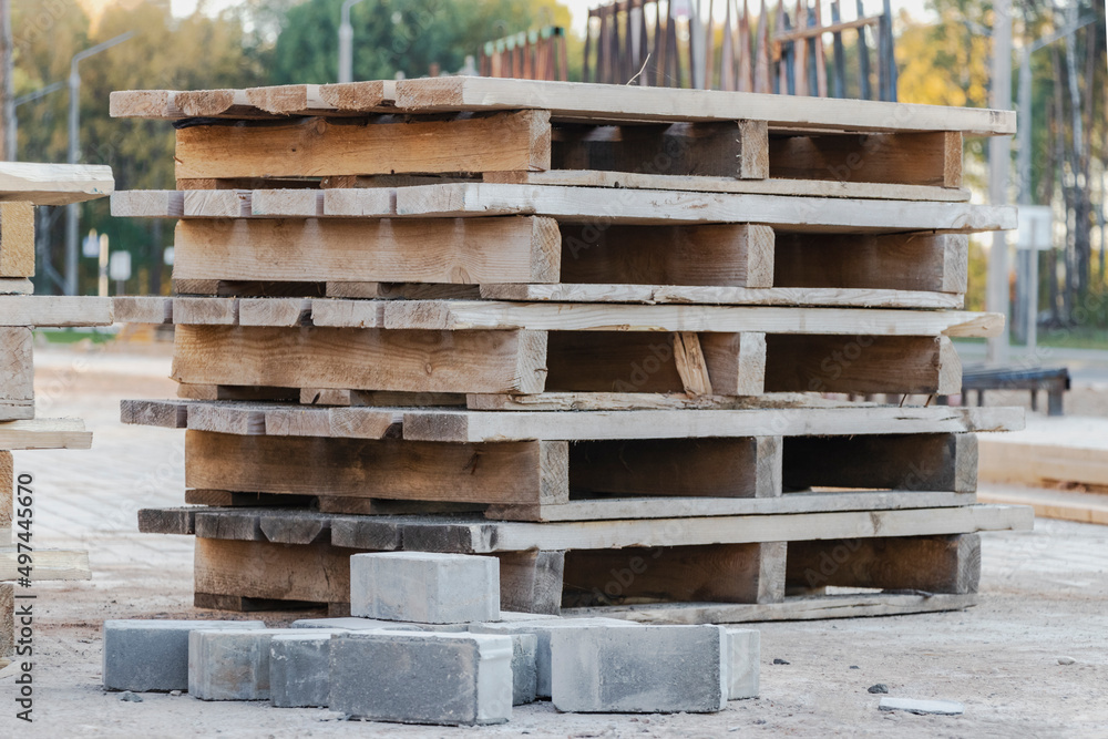 Empty pallets at a construction site. Reuse of wooden pallets in construction. Empty pallets at a construction site. Reuse of wooden pallets in construction.