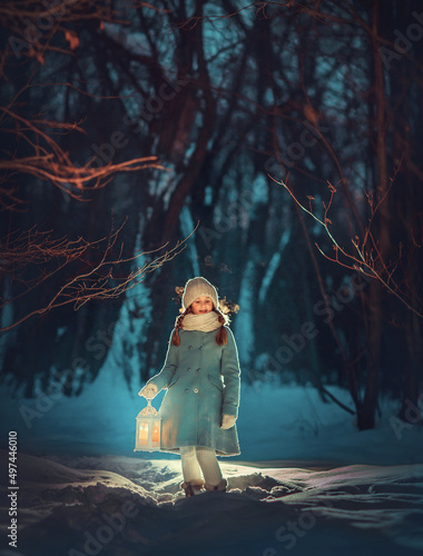 Girl with lantern walking in the night winter park