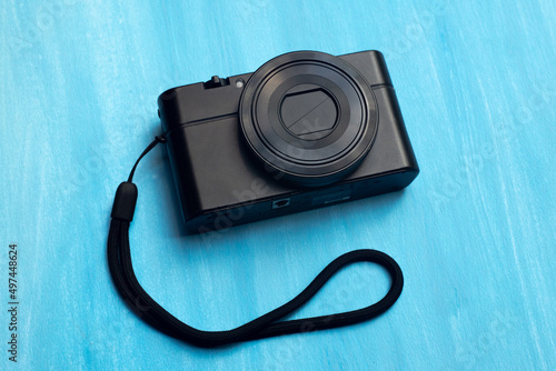 Compact black camera on a blue isolate. Camera soap dish on an artistic background of the color of the sea.