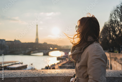 Young woman enjoying beautiful landscape view on the riverside  during the sunset in Paris. © Julija