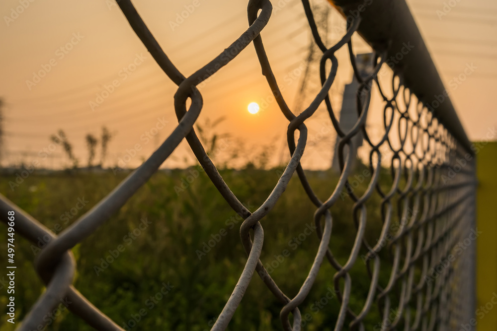 Looking thru the wire mesh steel to see the sunrire morning. Looking thru the wire mesh steel to see the sunrire morning.