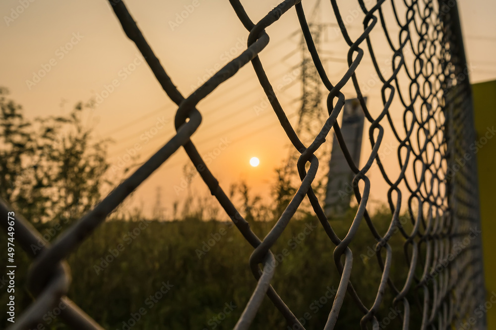 Looking thru the wire mesh steel to see the sunrire morning. Looking thru the wire mesh steel to see the sunrire morning.