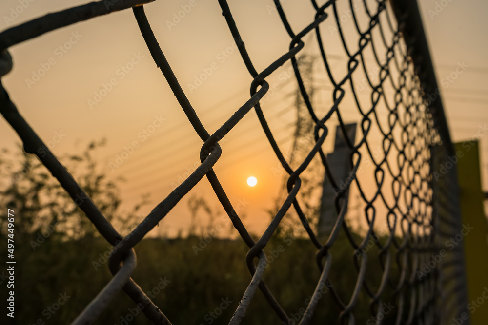 Looking thru the wire mesh steel to see the sunrire morning. Looking thru the wire mesh steel to see the sunrire morning.