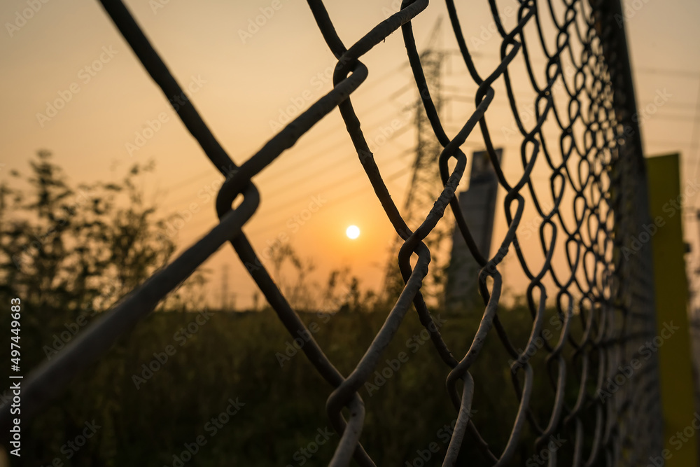 Looking thru the wire mesh steel to see the sunrire morning. Looking thru the wire mesh steel to see the sunrire morning.
