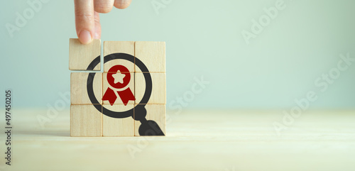 Quality warranty concept. Standardization, ISO. Hand placed wooden cubes with quality warranty icon on grey background.Used for banner and advertising premium product and service quality commitment. photo