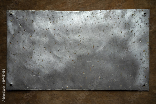 Tela Photo of an old aluminum plaque on a wooden background