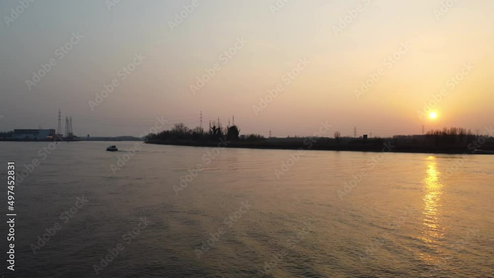Lonely boat sailing on river Scheldt during sunset time. Aerial view Lonely boat sailing on river Scheldt during sunset time. Aerial view