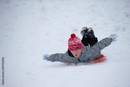 Child in winter. The boy is sledding.