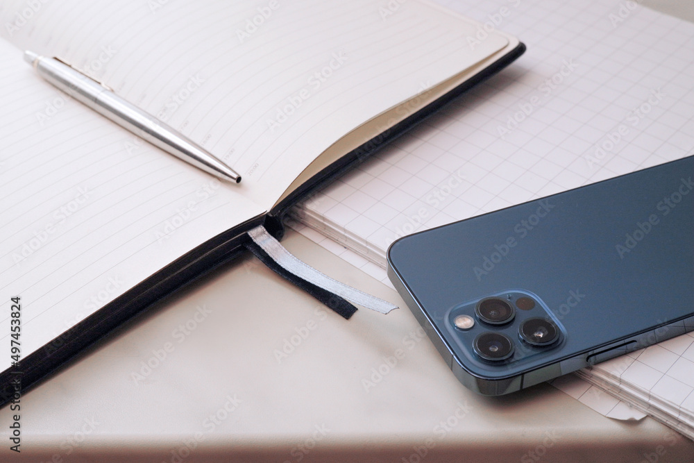 Fototapeta premium Communication technologies. On the table is a mobile phone, a diary, a pen.