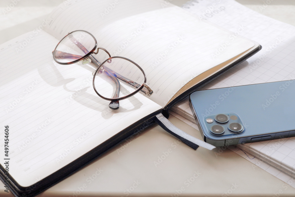 Working office table. On the table is a diary, glasses, a mobile phone. Working office table. On the table is a diary, glasses, a mobile phone.