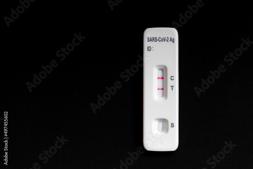 Positive self test and home Isolation concept, The rapid antigen test (ATK) with two stripes on black background, Coronavirus disease (COVID-19) is an infectious disease caused by the SARS-CoV-2 virus