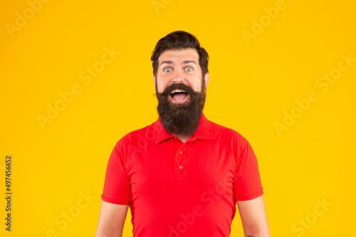 amazed guy with beard and hairstyle on yellow background, face