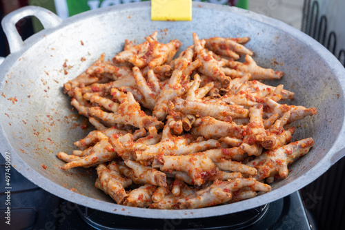 fried chicken feet in a frying pan and mixed with chili