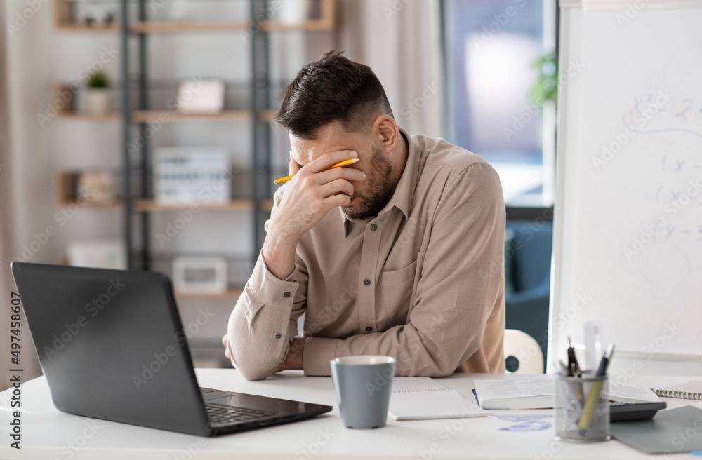 distance education, remote job and stress concept - tired male teacher with laptop computer working at home office distance education, remote job and stress concept - tired male teacher with laptop computer working at home office