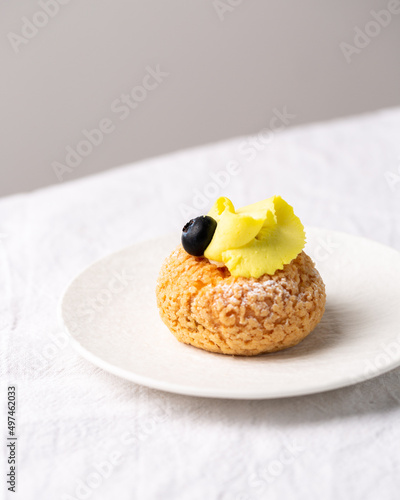 Modern sweet puffs - French choux pastry (eclairs) with lemon cream and blueberries photo