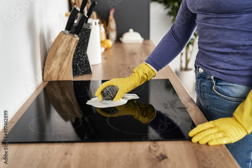 Close up of caucasian woman cleaning ceramic glass cooktop photo