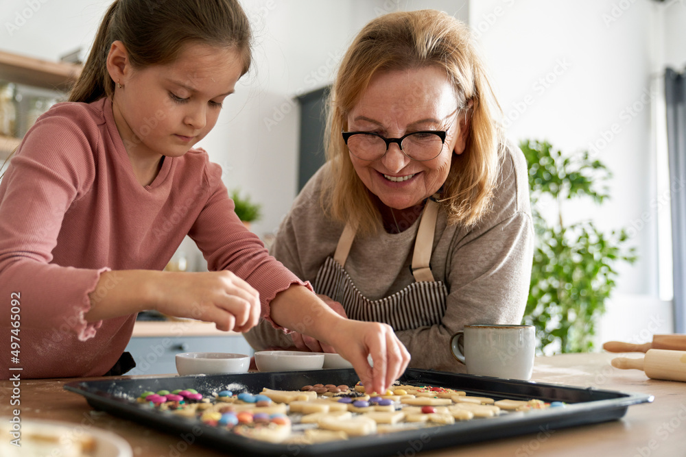 Fototapeta premium Caucasian of grandmother help her granddaughter bake cookies