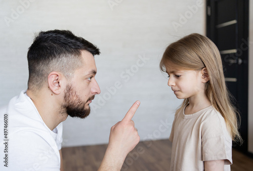 Domestic Violence. Man threatening his daughter with his fist. Domestic problem in family. Dad scolding his child. Focus on men.