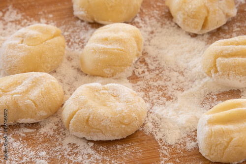 raw gnocchi on a wooden board with flour