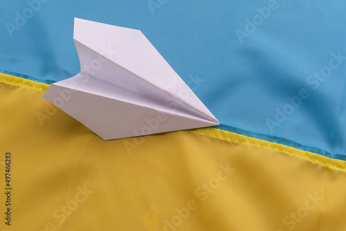 paper airplane on the background of the flag of Ukraine