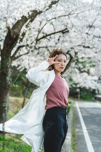 桜の花を見ながら散策する女性 © peach100
