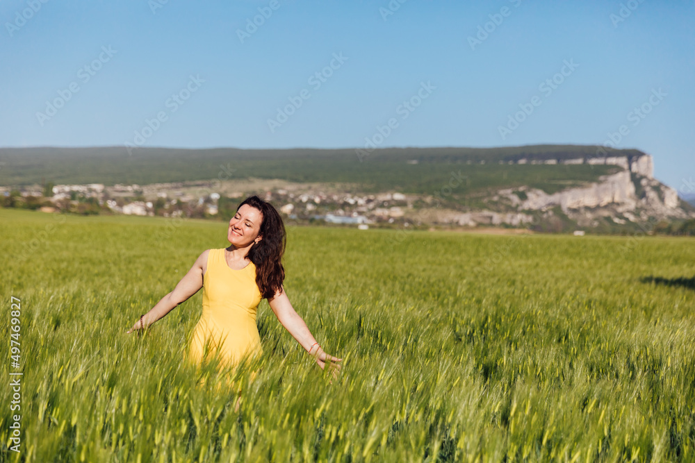 woman traveler in the field looks at the beautiful landscape