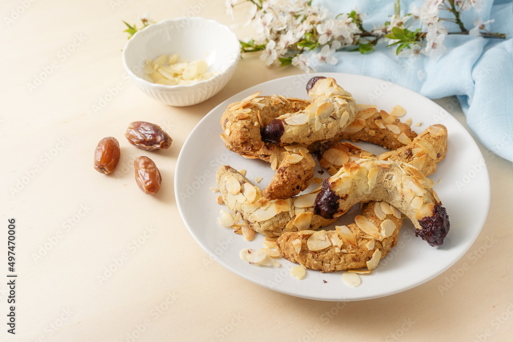Homemade cookies from almond, dates, oat flakes and dark chocolate without sugar, spring flower branch and blue napkin on a wooden table, copy space, selected focus Homemade cookies from almond, dates, oat flakes and dark chocolate without sugar, spring flower branch and blue napkin on a wooden table, copy space, selected focus