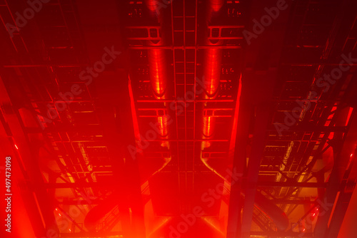 Metal structures of the bridge in red lighting. Abstract industrial background