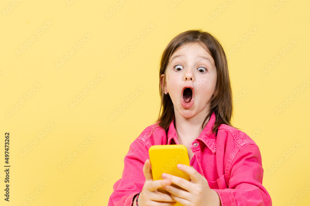 Surprised little girl looking at phone and using social media. Parental control on internet concept.