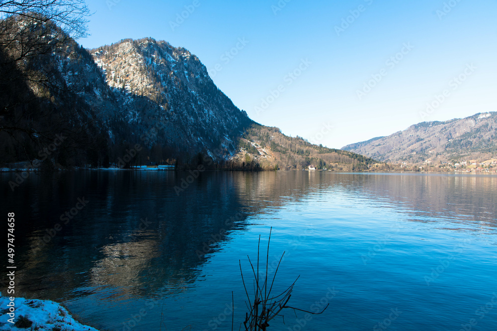 Attersee lake at Salzkammergut area in Austria.  Tree branches, beautiful blue sky and the alps mountains. Upper Austria, Europe