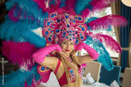 Dancer in a carnival costume with large colored feathers on a holiday