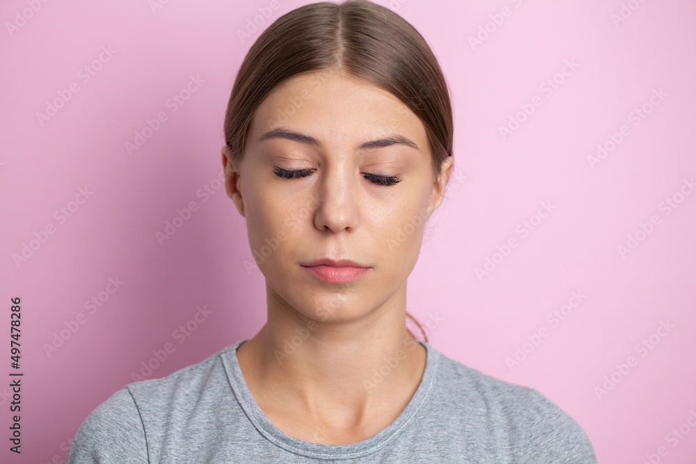 Portrait of a woman with closed eyes on a pink background Portrait of a woman with closed eyes on a pink background
