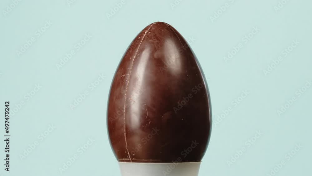 Chocolate Easter egg spinning on a blue background Chocolate Easter egg spinning on a blue background