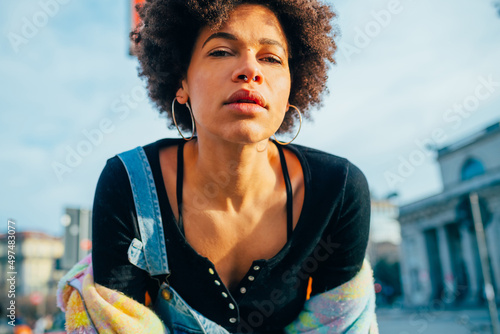 Portrait young black woman posing outdoor looking camera serious cool attitude