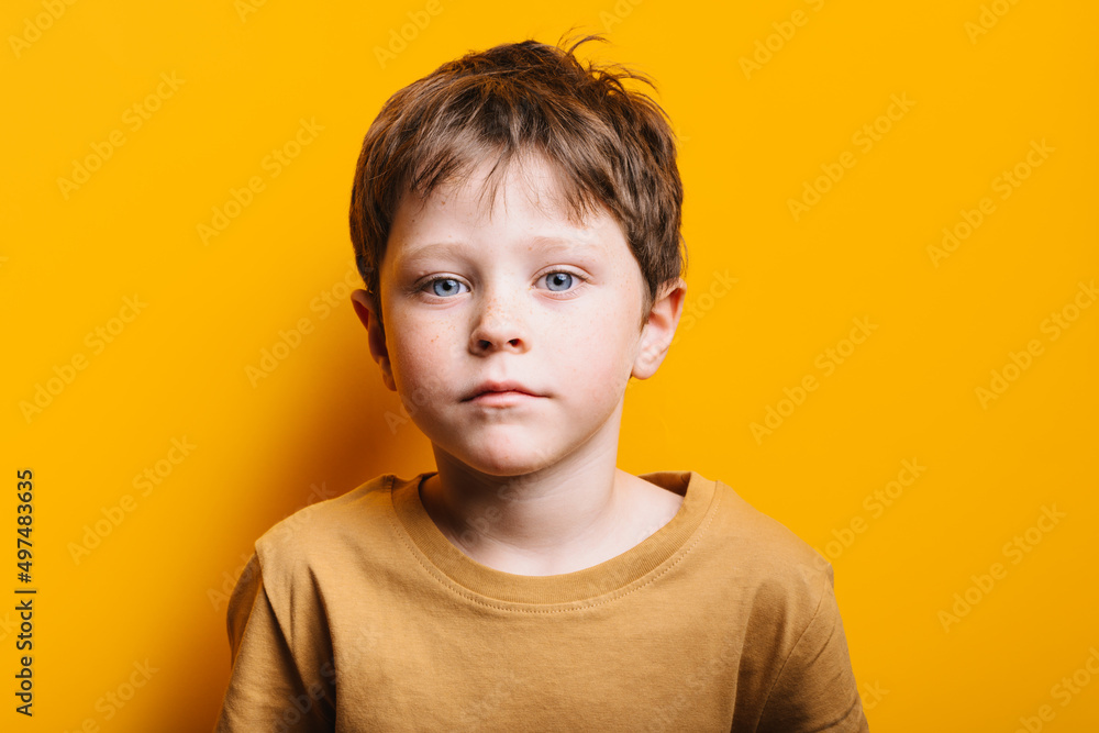 portrait of a serious child on a yellow background portrait of a serious child on a yellow background