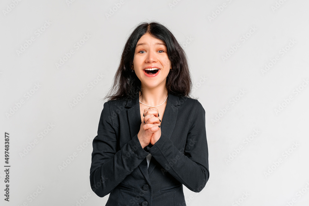 Portrait of dreamy brunette teen girl in black blazer making wish, daydreaming about having something, clench fists close to chest, praying hopeful. Luck, celebration and dreams concept Portrait of dreamy brunette teen girl in black blazer making wish, daydreaming about having something, clench fists close to chest, praying hopeful. Luck, celebration and dreams concept