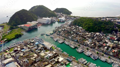 Aerial view showing Suao harbor in Taiwan with mountain islands bay,docking boats and ships during sunny day photo