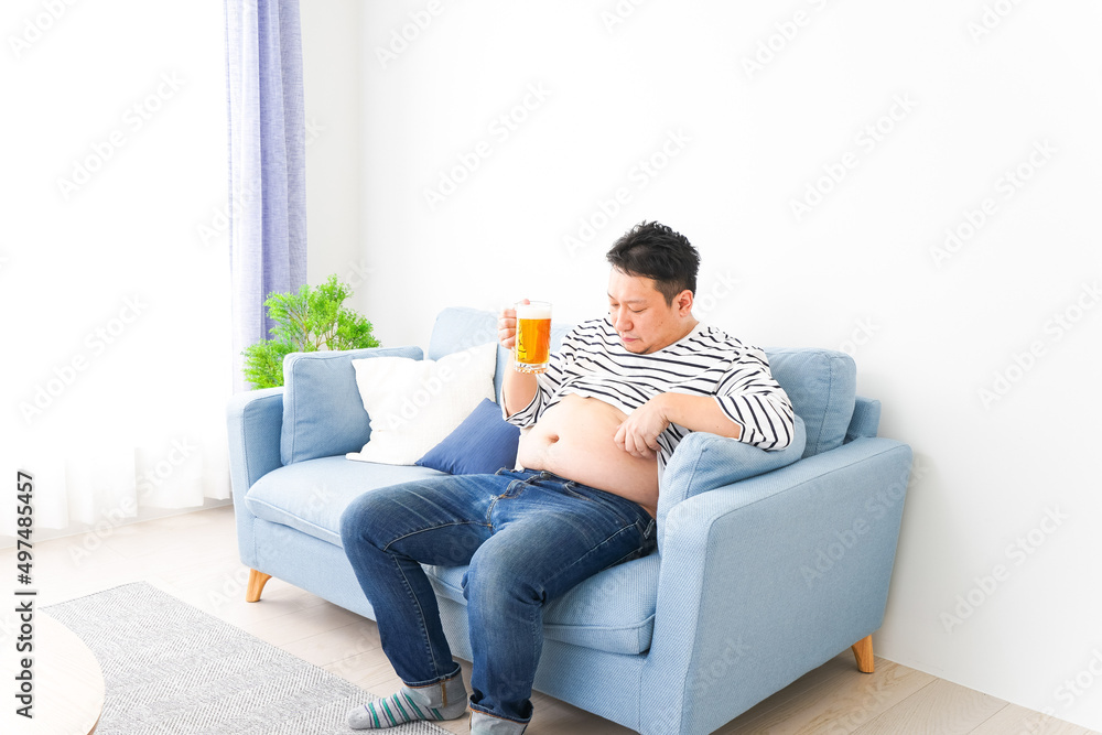 自宅でビールを飲む中年の男性 自宅でビールを飲む中年の男性