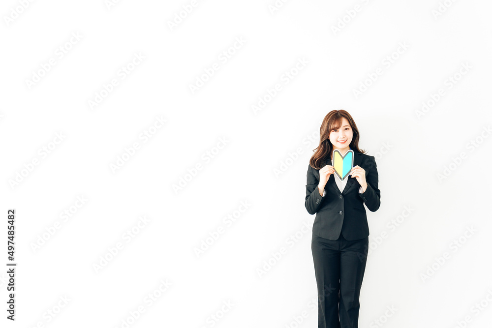 初心者マークを持つスーツを着た若いビジネスウーマン